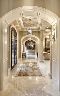 an elegant hallway with marble floors and chandeliers