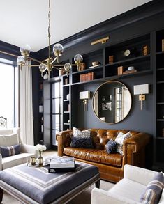 a living room filled with furniture and a large mirror on the wall above it's windows