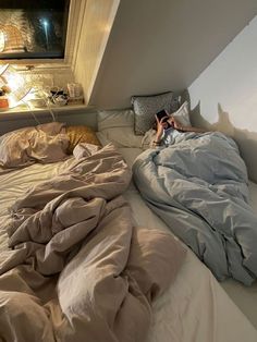 a person laying in bed with an unmade comforter on top of the sheets