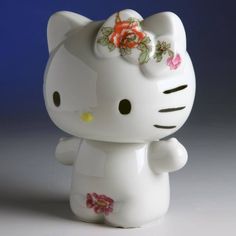 a white hello kitty figurine with flowers on it