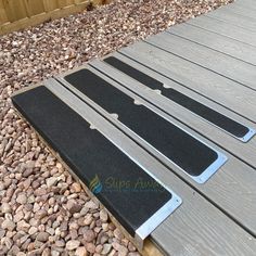 the steps are made out of wood and have black rubber mats on them, along with gravel