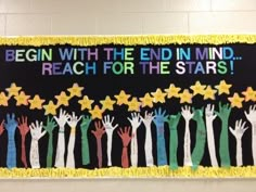 a bulletin board with hands and stars on it