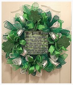 a st patrick's day wreath with shamrocks and ribbons on the front door