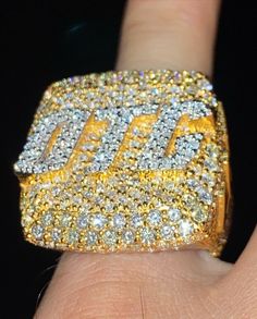 a person's hand with a yellow and white diamond ring on it