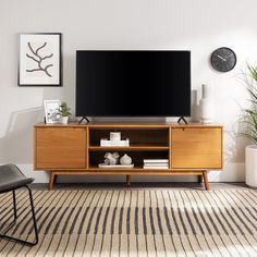 a flat screen tv sitting on top of a wooden entertainment center in a living room