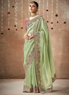 Get ready to dazzle in our Pista Green Sequins And Embroidered Organza Saree! This stylish saree is perfect for your bridal or wedding wear, featuring contrast onion pink embroidery and a fancy blouse. Light and elegant, this saree will make you stand out and feel confident on your special day. The unstitched blouse can be customized upto 44 inches. Do Note: All the accessories shown are for styling purpose only. Slight color variation may occur due to photographic reasons. Fall and Pico : Done Green And Pink Saree, Light Green Saree, Sage Green And Pink, Saree With Contrast Blouse, Sequins Saree, Classic Saree, Pista Green, Designer Silk Sarees, Bridal Elegance