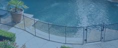 a pool with a fence around it and a potted plant next to the pool