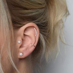 a close up of a person with ear piercings on their ears and behind the ear