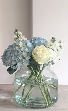 white and blue flowers in a glass vase