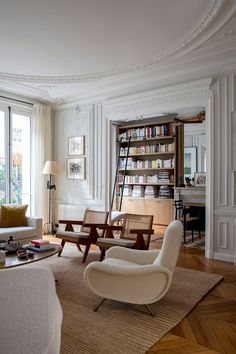 a living room filled with furniture and bookshelves