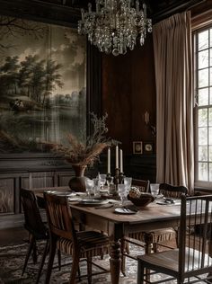 a dining room table with chairs and a chandelier hanging from it's ceiling