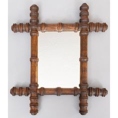 an old wooden frame mirror on a white wall