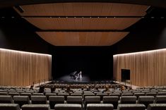 an empty auditorium with people sitting in chairs