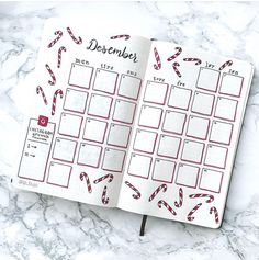 an open planner with candy canes on it and the word december written in red