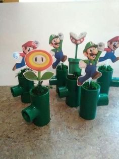 there are many potted plants with mario and luigi characters on them in front of a white wall