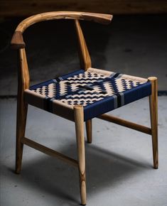 a wooden chair with a blue and white patterned seat pad on it's back