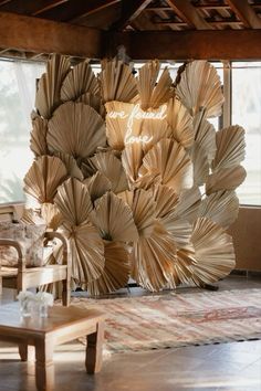 a large sculpture made out of books in a living room next to a chair and table