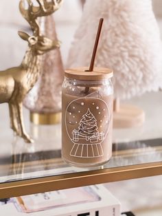 a glass jar filled with a drink sitting on top of a table next to christmas decorations