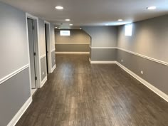 an empty room with hard wood floors and gray walls