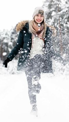 a woman is walking through the snow in winter