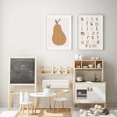 a living room filled with furniture and pictures on the wall next to a table in front of a blackboard