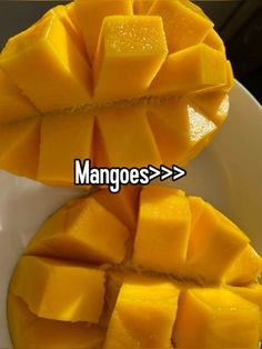 mangoes are cut in half and placed on a white plate with the words mangoes > > >