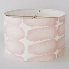 a pink and white lamp shade with gold trim on the bottom that has an animal print pattern