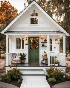 a white house with green front door and porch