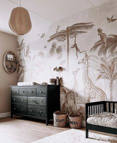 a baby's room with a giraffe mural on the wall and a crib