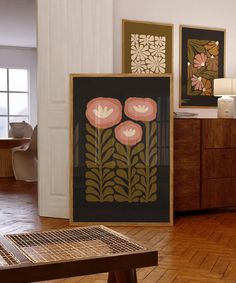 two framed art pieces on the wall in a room with wood floors and wooden furniture