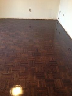 an empty room with hard wood flooring and white walls