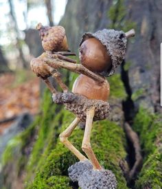 a small figurine is standing in the mossy ground next to a tree