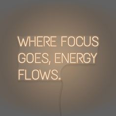 there is a neon sign that says where focus goes, energy flows