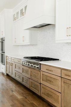 a kitchen with white cabinets and wood floors is pictured in this image from the front view