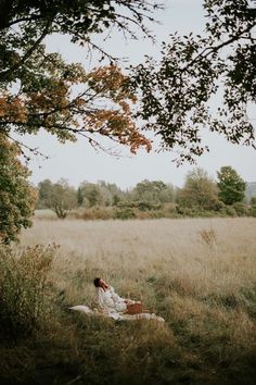 a woman sitting in the middle of a field