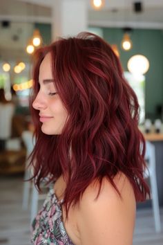 Woman with wavy, shoulder-length red hair smiling softly in a brightly lit room. Burgundy Hairstyles, Small Highlights, Red Purple Hair, Wine Hair Color, Textured Lob, Burgundy Highlights, Cherry Red Hair, Mermaid Hair Color, Red Hair Inspo