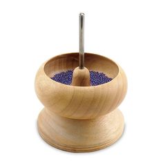 a wooden bowl with a blue dot inside and a metal tip sticking out of it