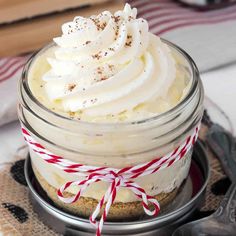 a dessert in a glass jar with whipped cream and candy canes on the rim