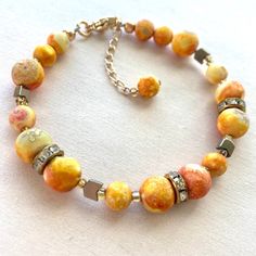 Sunrise beaded bracelet in 14kt gold filled hardware. Adjustable from 7 inches to 8.5 inches. Handmade using beads made of agate and gold plated hematite.  ⚠️No one bracelet is exactly like the other! there are many differences in bead color and pattern!⚠️ 💪Strong 49-Strand beadalon wire and crimps are used in this bracelet.  ✨Take good care of your jewelry. Store in box and clean off tarnish using cloth provided. Take your jewelry off to shower, workout, and put on cosmetics. Gold Beaded Bracelet With Colorful 14k Gold Filled Beads, 14k Gold-filled Beaded Bracelets With Colorful Beads, Elegant Yellow Beaded Bracelets With Gold Beads, Elegant Yellow Beaded Bracelet With Gold Beads, Handmade Gold Crystal Bracelet With Round Beads, Handmade 14k Gold Filled Beaded Bracelets, Adjustable Orange Agate Bracelets, Adjustable Orange Agate Bracelet, Handmade Orange Agate Bracelets