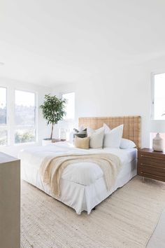 a bedroom with white walls and carpeted flooring, large bed in the middle