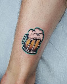 a person with a tattoo on their arm holding a beer mug