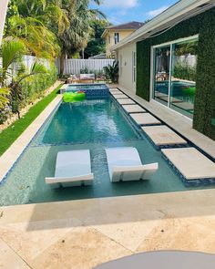 a swimming pool with lounge chairs next to it