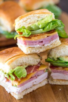 four sandwiches stacked on top of each other with lettuce and ham in between them