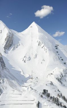 a ski lift going up the side of a snow covered mountain