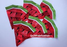 four pieces of red and green fabric are laid out on a white surface with the words quiltfabrication