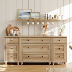 a wooden dresser sitting next to a wall with pictures on it's shelf above it