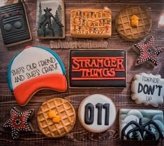 decorated cookies with the words strange things and other items on them are arranged in rows