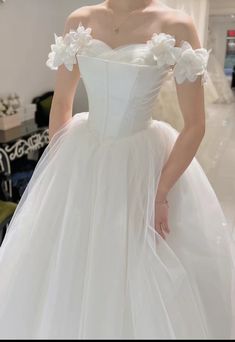 a woman in a white wedding dress with flowers on it