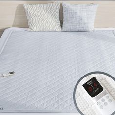 an alarm clock sitting on top of a bed next to pillows and pillow shampoos