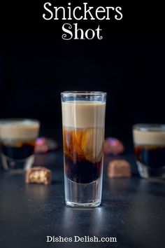 two shot glasses filled with liquid on top of a table